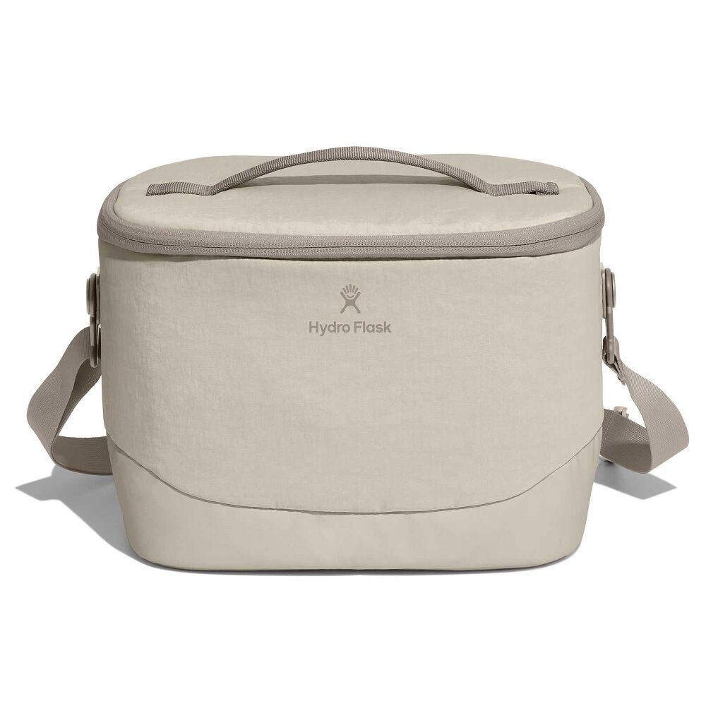 Beige Hydro Flask soft-sided cooler bag with rectangular rounded-top shape, top carry handle, full-zip lid, adjustable shoulder strap, and reinforced bottom.